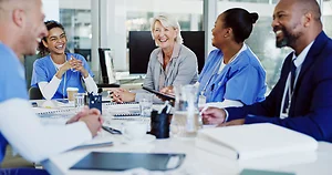 Boardroom, collaboration and healthcare with hospital manager speaking to staff for medical planning. Administration, corporate and management with professional talking to medicine team in clinic